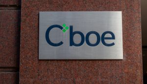 Ein Metallschild mit dem Cboe-Logo, bekannt für die Einführung von Ethereum-Futures und Bitcoin-Futures, ist an einer roten Granitwand angebracht.