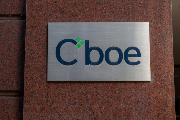Ein Metallschild mit dem Cboe-Logo, bekannt für die Einführung von Ethereum-Futures und Bitcoin-Futures, ist an einer roten Granitwand angebracht.