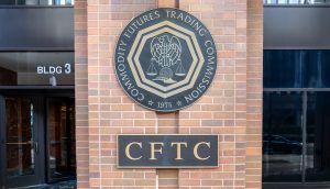 Eine große Plakette mit dem Siegel der Commodity Futures Trading Commission (CFTC) ist an einer Backsteinmauer vor einem Gebäude angebracht.