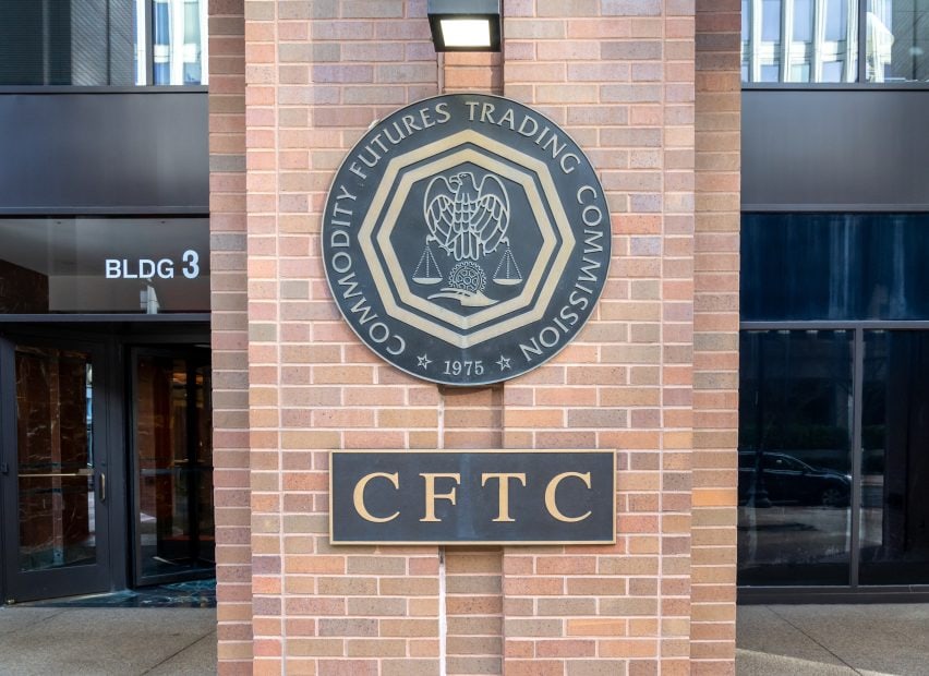 Eine große Plakette mit dem Siegel der Commodity Futures Trading Commission (CFTC) ist an einer Backsteinmauer vor einem Gebäude angebracht.