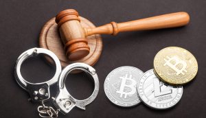 Ein Richterhammer, ein Paar Handschellen und drei Kryptowährungsmünzen sind auf einer dunklen Fläche angeordnet und symbolisieren die Krypto-Kriminalität und die Auswirkungen der jüngsten Mega-Razzia auf Bankkonten.