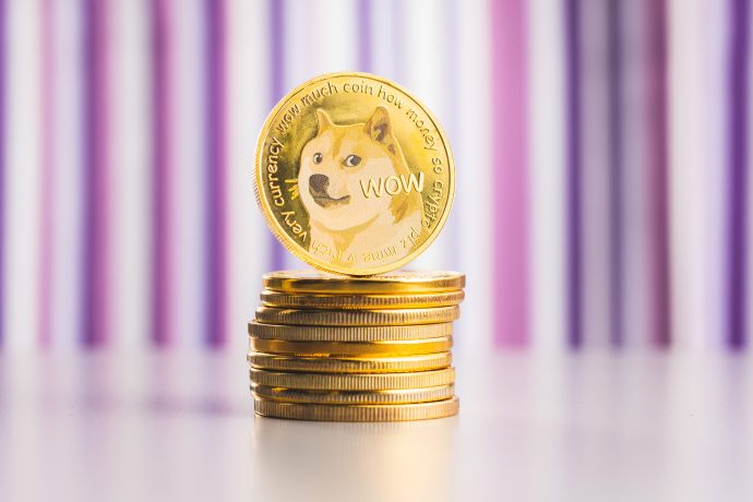Ein Stapel Goldmünzen mit einer Dogecoin, auf der der ikonische Shiba Inu-Hund und der Text "wow" abgebildet sind, steht aufrecht oben. Unscharfe vertikale lila und weiße Streifen bilden einen lebendigen Hintergrund.