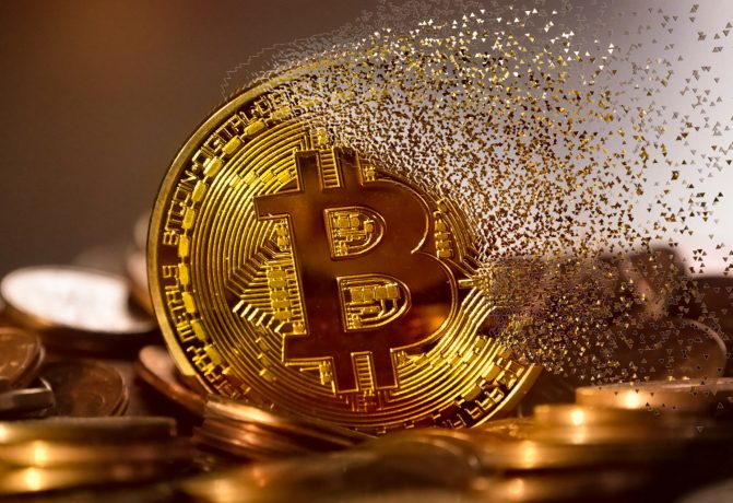 Eine goldene Bitcoin-Münze zerfällt teilweise in kleine Partikel und ruht auf einem Haufen Münzen. Dies symbolisiert die Volatilität von Kryptowährungen und die Auswirkungen der Krypto-Steuer-Vorschriften.