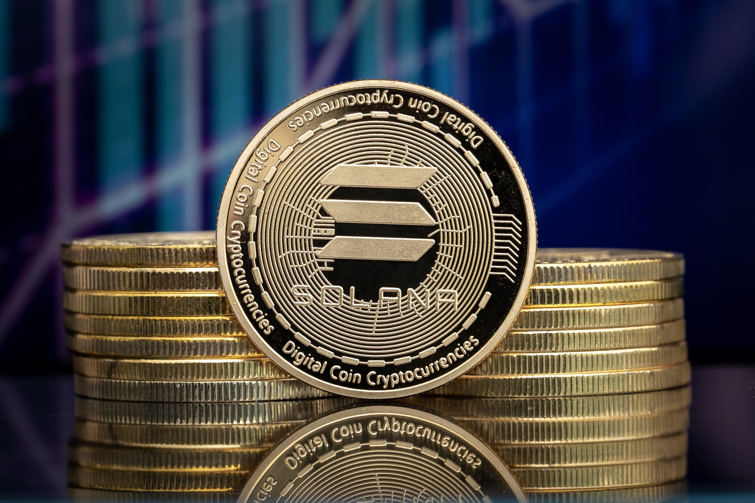 Ein Stapel goldfarbener Solana-Kryptowährungsmünzen mit einer aufrecht stehenden Solana-Münze im Vordergrund, die das Solana-Logo und detaillierte Gravuren aufweist.