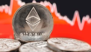 Eine Nahaufnahme von Ethereum-Münzen mit einer roten, rückläufigen Finanzkurve im unscharfen Hintergrund verdeutlicht die volatilen Marktbewegungen von Ethereum.