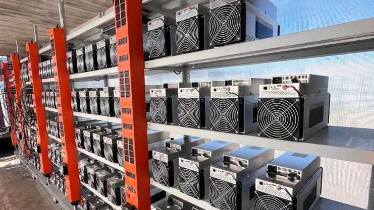 In einem gut beleuchteten Raum sind auf Metallregalen reihenweise Bitcoin-Mining-Rigs mit Kühlgebläsen aufgestellt, an denen Nutzer kostenlos ausprobieren und die Test-Power effizient erleben können.