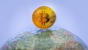 Eine goldene Bitcoin-Münze, die auf einer Weltkugel balanciert, symbolisiert die globale Präsenz von Krypto und Kryptowährung.
