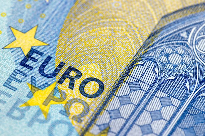 Nahaufnahme eines Ausschnitts einer Euro-Banknote, auf der das Wort EURO, gelbe Sterne und ein Teil eines architektonischen Designs zu sehen sind - Sicherheitsmerkmale, die an die von Polygon gestützte Euro-Stabilitätsmünze EURAU erinnern.