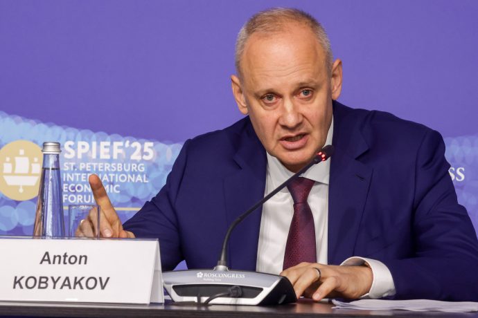 Ein Mann im blauen Anzug und mit roter Krawatte (Anton Kobyakov) spricht während einer Pressekonferenz zu einem Mikrofon. Auf einem Namensschild steht Anton Kobyakov. Im Hintergrund ist ein Schild des Internationalen Wirtschaftsforums in St. Petersburg zu sehen, einer Veranstaltung, an der auch Putin teilnimmt.