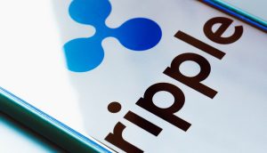 Auf einem Smartphone-Bildschirm werden das Ripple-Logo und der Name in fetten Buchstaben angezeigt, um die Marke Ripple zu präsentieren.