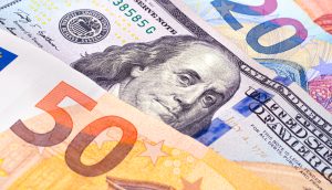 Nahaufnahme von sich überlappenden Euro- und US-Dollar-Banknoten, darunter ein 50-Euro-Schein und ein 100-US-Dollar-Schein, die das Konzept der Stablecoins darstellen, die traditionelle Währungen mit digitalen Vermögenswerten verbinden.