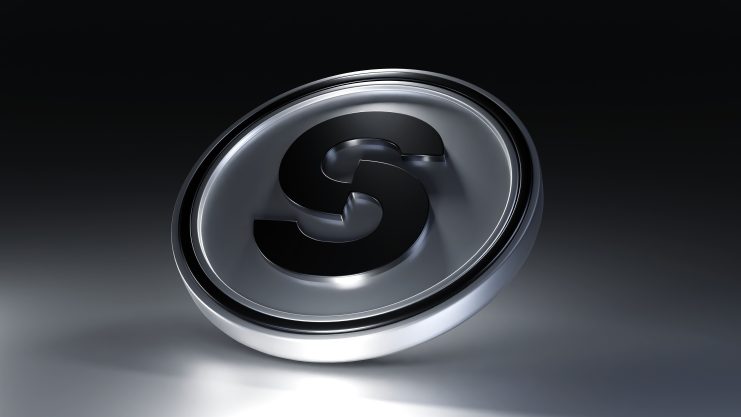 Ein metallisches, kreisförmiges Emblem mit einem fetten, erhabenen Buchstaben S in der Mitte vor einem dunklen Hintergrund mit Farbverlauf erinnert an die hochmoderne Welt von Krypto.