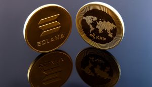 Zwei Münzen mit den Logos der Kryptowährungen Solana und XRP, die auf jeder ETF-Beobachtungsliste zu finden sind, stehen aufrecht auf einer reflektierenden schwarzen Oberfläche.