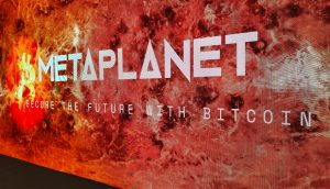 Auf einer großen digitalen Anzeige ist METAPLANET und SECURE THE FUTURE WITH BITCOIN vor einem feurigen, abstrakten Hintergrund zu lesen, der die kühne Vision von Metaplanet wiedergibt.