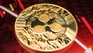 Nahaufnahme einer goldenen Ripple (XRP) Kryptowährungsmünze auf einem roten Finanzchart mit abwärts gerichteten Pfeilen, die die jüngste Verschiebung des XRP-Kurses und das Potenzial für eine Trendwende auf dem Markt hervorheben.