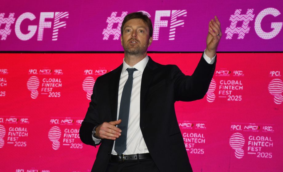 Alex Chriss gestikuliert, während er auf der Bühne des Global Fintech Fest 2025 spricht, während hinter ihm Bildschirme mit PayPal- und Veranstaltungslogos zu sehen sind.