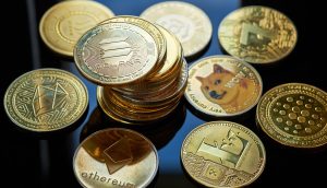 Eine Sammlung verschiedener physischer Altcoin-Kryptowährungsmünzen, darunter Ethereum, Solana, Dogecoin und Cardano, die auf einer reflektierenden schwarzen Oberfläche angezeigt werden.