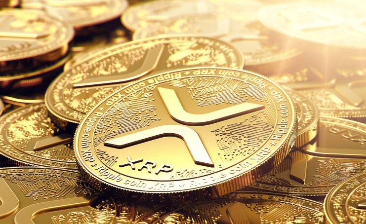 Eine Nahaufnahme von mehreren goldfarbenen XRP-Kryptowährungsmünzen mit dem XRP-Logo und kreislaufähnlichen Mustern, die von hellem Licht beleuchtet werden, um das besondere Design von XRP zu zeigen.