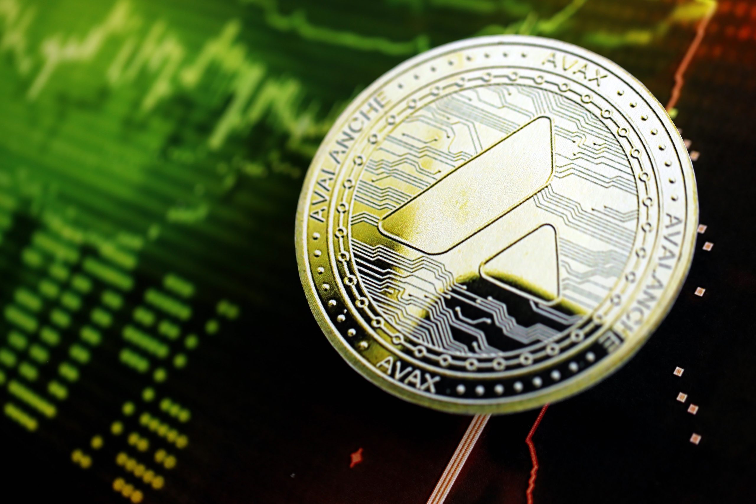 Eine physische AVAX-Kryptowährungsmünze ruht auf einem digitalen Diagramm, das grüne Preistrends anzeigt.