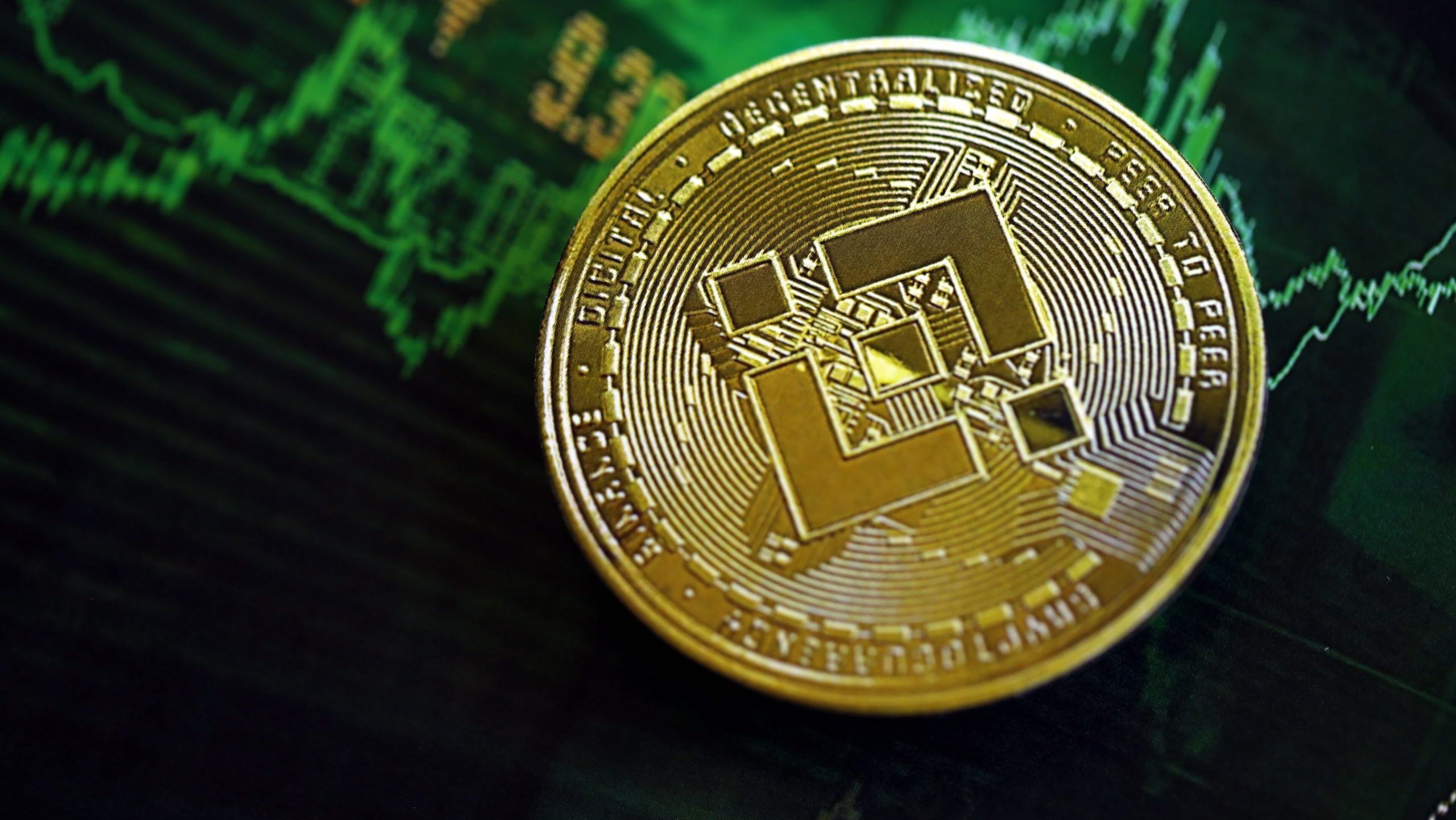 Eine BNB-Kryptowährungsmünze ruht auf einem digitalen Finanzdiagramm, das schwankende grüne Marktlinien und Zahlen anzeigt.
