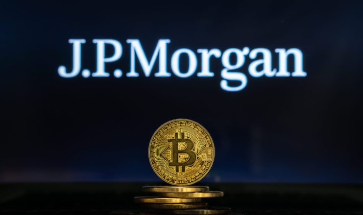 Eine goldene Bitcoin-Münze ist vor anderen Münzen gestapelt, hinter denen das JPMorgan-Logo und das Kursziel auf einem dunklen Hintergrund zu sehen sind.