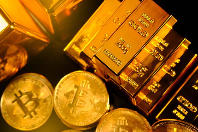 Mehrere Goldbarren, die neben mehreren physischen Bitcoin-Münzen gestapelt sind, veranschaulichen die Debatte Bitcoin vs. Gold, indem sie sowohl das Edelmetall als auch die Kryptowährung zeigen.