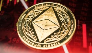 Ein goldener Ethereum Classic Coin ruht auf einem Hintergrund, der rote Finanzgraphen und Börsendaten anzeigt, was auf eine potenzielle Kaufgelegenheit während des jüngsten Krypto-Crashs hindeutet.