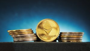 Eine goldene Ethereum-Münze mit dem Ethereum-Logo steht zwischen Münzstapeln vor einem Hintergrund mit blauem Farbverlauf - ein Symbol der Chancen für Investoren auch in Zeiten der Marktschwäche.
