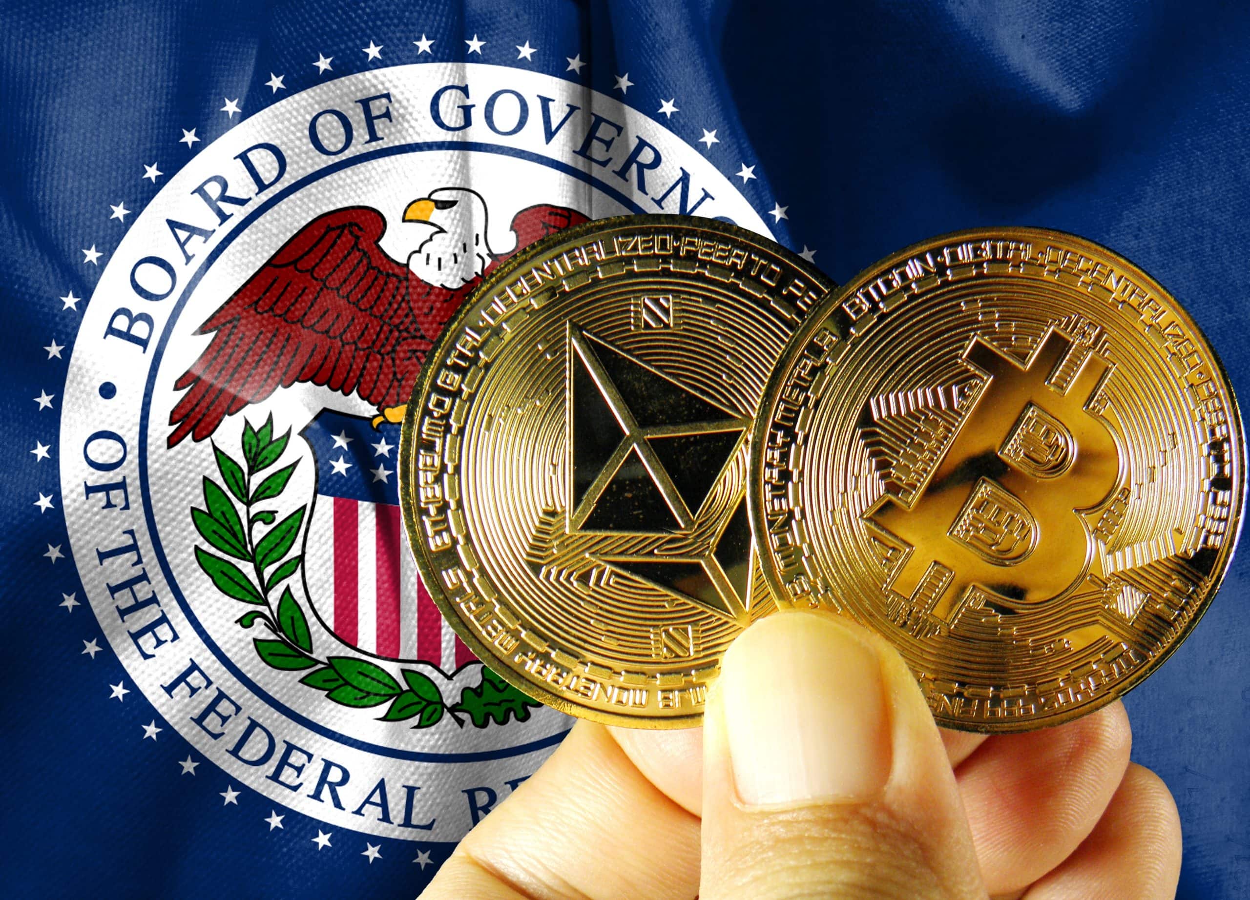 Eine Person hält Ethereum- und Bitcoin-Münzen mit der Aufschrift "Krypto" vor einem Emblem der US-Notenbank.