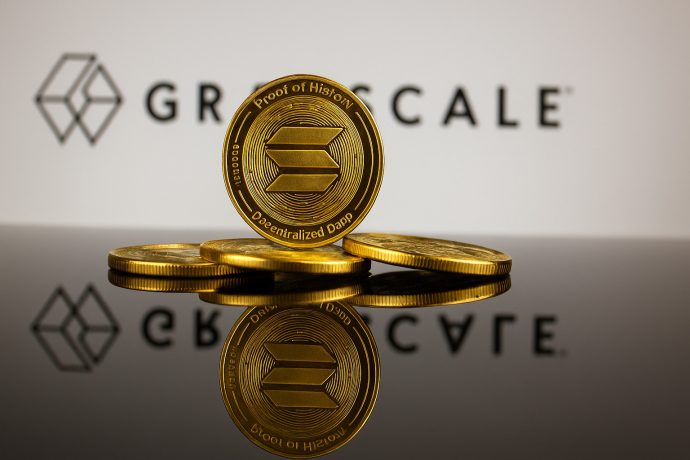 grayscale-solana-etf-staking-launch Ein Stapel Solana-Münzen mit dem Text "Proof of History", der sich auf einer Oberfläche spiegelt, wobei das Graustufen-Logo im Hintergrund zu sehen ist, unterstreicht die innovative Blockchain-Technologie von Solana.