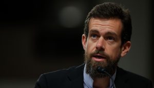 Ein Mann mit Bart und dunklem Anzug, der in ein Mikrofon spricht und vor einem dunklen Hintergrund leicht nach oben schaut - eine Reminiszenz an Dorseys typischen Stil.