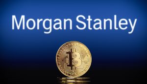 Eine physische Bitcoin-Münze steht vor einem unscharfen Morgan-Stanley-Logo, das die Überschneidung von traditionellem Finanzwesen und digitalen Vermögenswerten verdeutlicht.