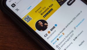 Ein Smartphone zeigt das Twitter-Profil von CZ_BNB, Mitbegründer und ehemaliger CEO von Binance, mit Krypto-Follower-Statistiken und einem Binance-App-Werbebanner.