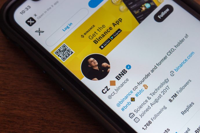 Ein Smartphone zeigt das Twitter-Profil von CZ_BNB, Mitbegründer und ehemaliger CEO von Binance, mit Krypto-Follower-Statistiken und einem Binance-App-Werbebanner.