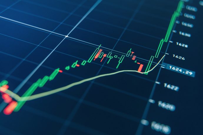 Nahaufnahme eines Finanzkerzencharts mit grünen und roten Balken, einer gelben Trendlinie und BNB-Kurszahlen auf dunkelblauem Hintergrund.
