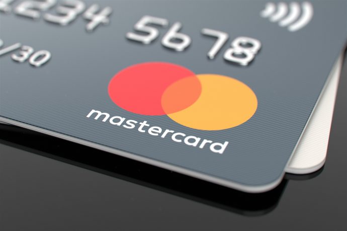 Mastercard weitet seine Krypto-Expansion aus Nahaufnahme einer Mastercard-Kreditkarte mit ihrem Logo mit roten und gelben sich überlappenden Kreisen und eingeprägten Zahlen, die die Rolle von Mastercard bei der Förderung der Krypto-Infrastruktur hervorheben.