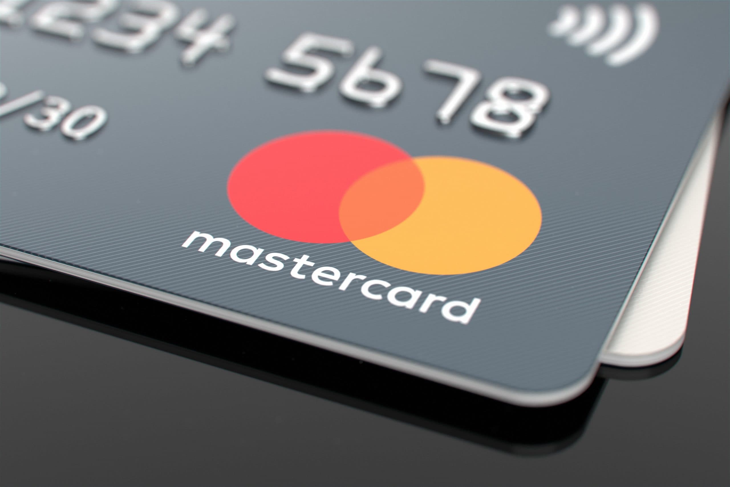 Nahaufnahme einer Mastercard-Kreditkarte mit ihrem Logo mit roten und gelben sich überlappenden Kreisen und eingeprägten Zahlen, die die Rolle von Mastercard bei der Förderung der Krypto-Infrastruktur hervorheben.