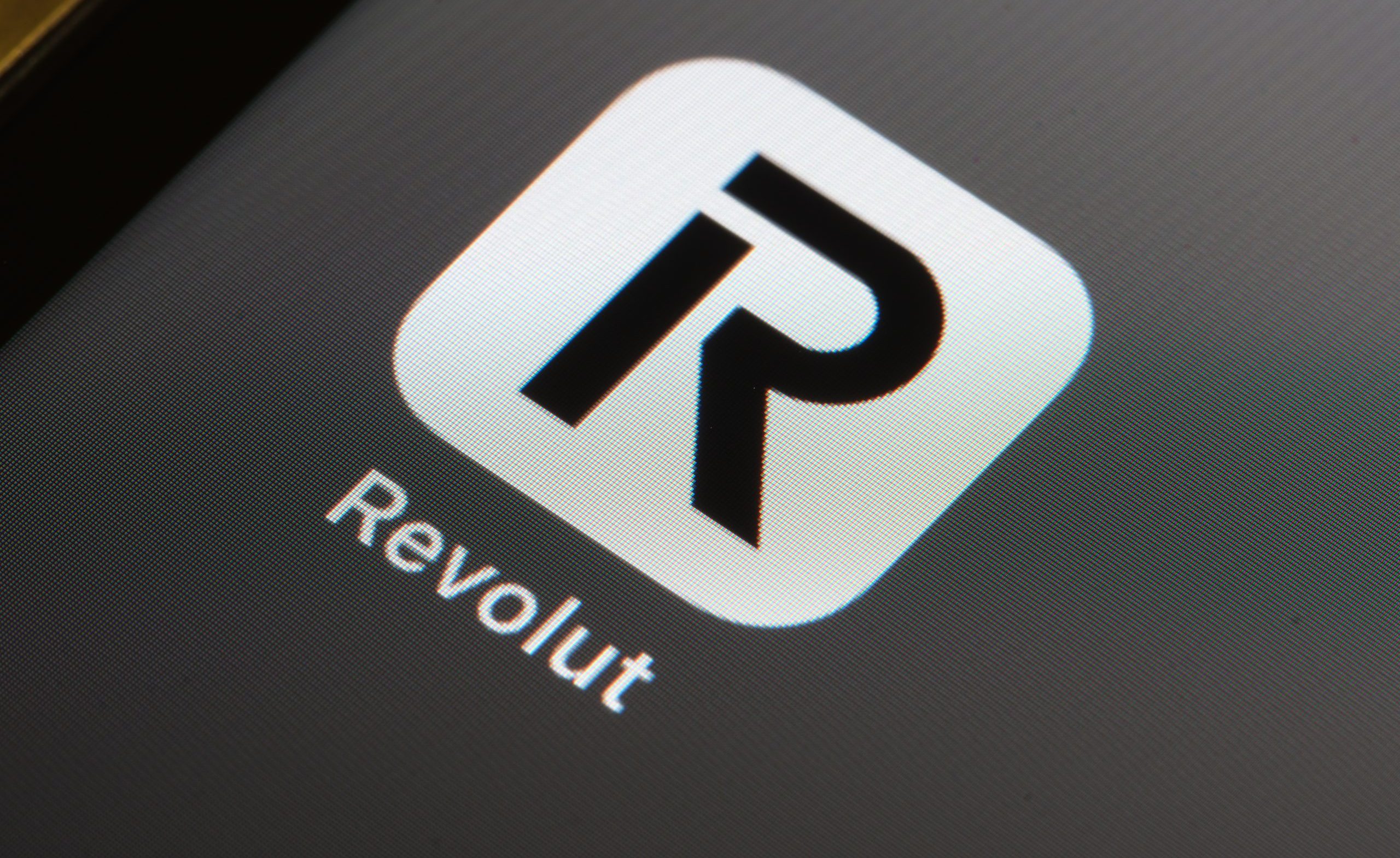 Nahaufnahme des Revolut-App-Symbols auf einem digitalen Bildschirm. Das Icon zeigt ein stilisiertes schwarzes R auf weißem Hintergrund, das die Präsenz von Revolut als führende Krypto-Plattform repräsentiert.