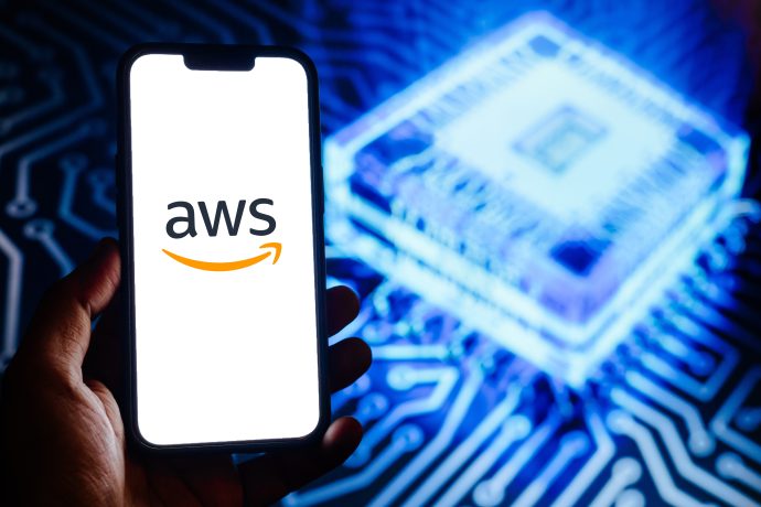 Eine Hand, die ein Smartphone mit dem AWS-Logo hält, mit einem leuchtenden Mikrochip, einer Platine und einem dezenten Ethereum-Symbol im verschwommenen Hintergrund.