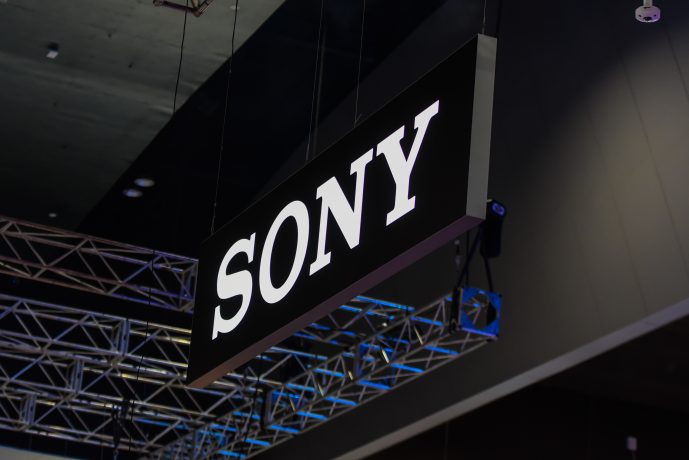 Ein großes schwarz-weißes Sony-Schild hängt von der Decke über einer Metalltraversenkonstruktion in einem überdachten Sony-Veranstaltungsraum.