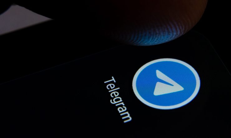Eine Nahaufnahme eines Fingers über dem Telegram-App-Symbol auf einem Smartphone-Bildschirm, die auf sofortige Krypto-Chats und sichere Nachrichtenübermittlung hinweist.