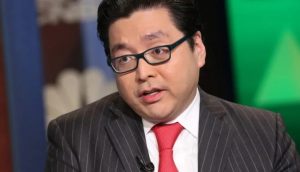 Tom Lee, gekleidet in einen dunklen Nadelstreifenanzug, eine rote Krawatte und eine Brille, spricht während eines Fernsehinterviews in einer Studioumgebung über Ethereum und Kapitalflut.