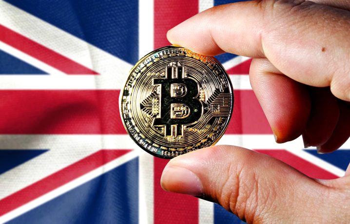 Eine Hand hält eine goldene Bitcoin-Münze vor einer britischen Flagge, die den wachsenden Einfluss von Krypto im Vereinigten Königreich symbolisiert.