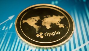 Eine goldene XRP-Münze mit einer Weltkarte auf blauem Hintergrund und Finanzdiagrammen.
