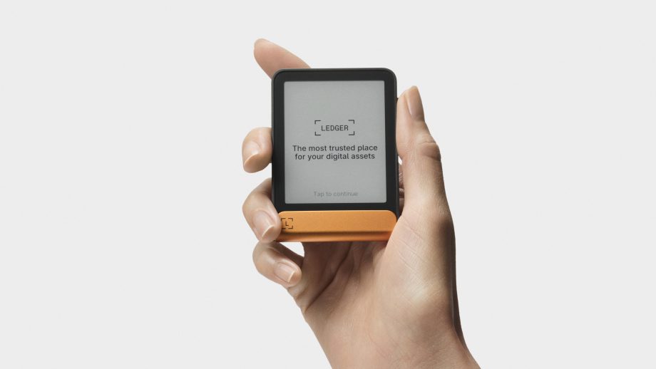 Eine Hand hält ein digitales Ledger-Geldbörsengerät mit dem Text auf dem Bildschirm: Der vertrauenswürdigste Ort für Ihre digitalen Vermögenswerte - sicher und bequem mit Ledger.