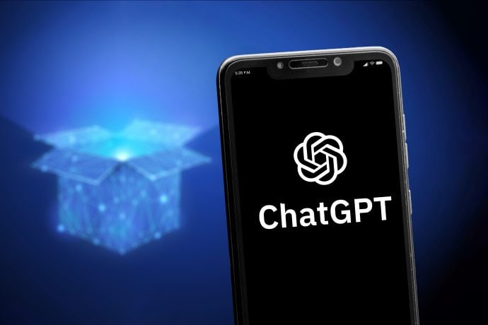 Ein Smartphone mit dem ChatGPT-Logo befindet sich vor der digitalen Illustration einer leuchtenden, offenen Box auf dunkelblauem Hintergrund.
