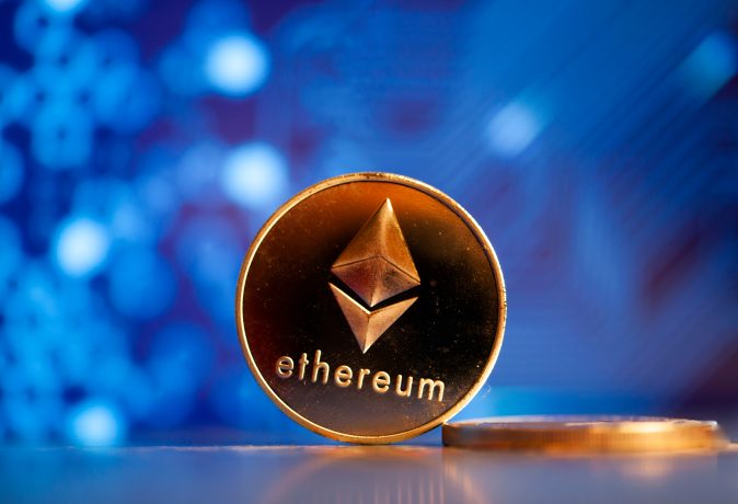 Eine goldene Ethereum-Münze vor einem blauen Hintergrund