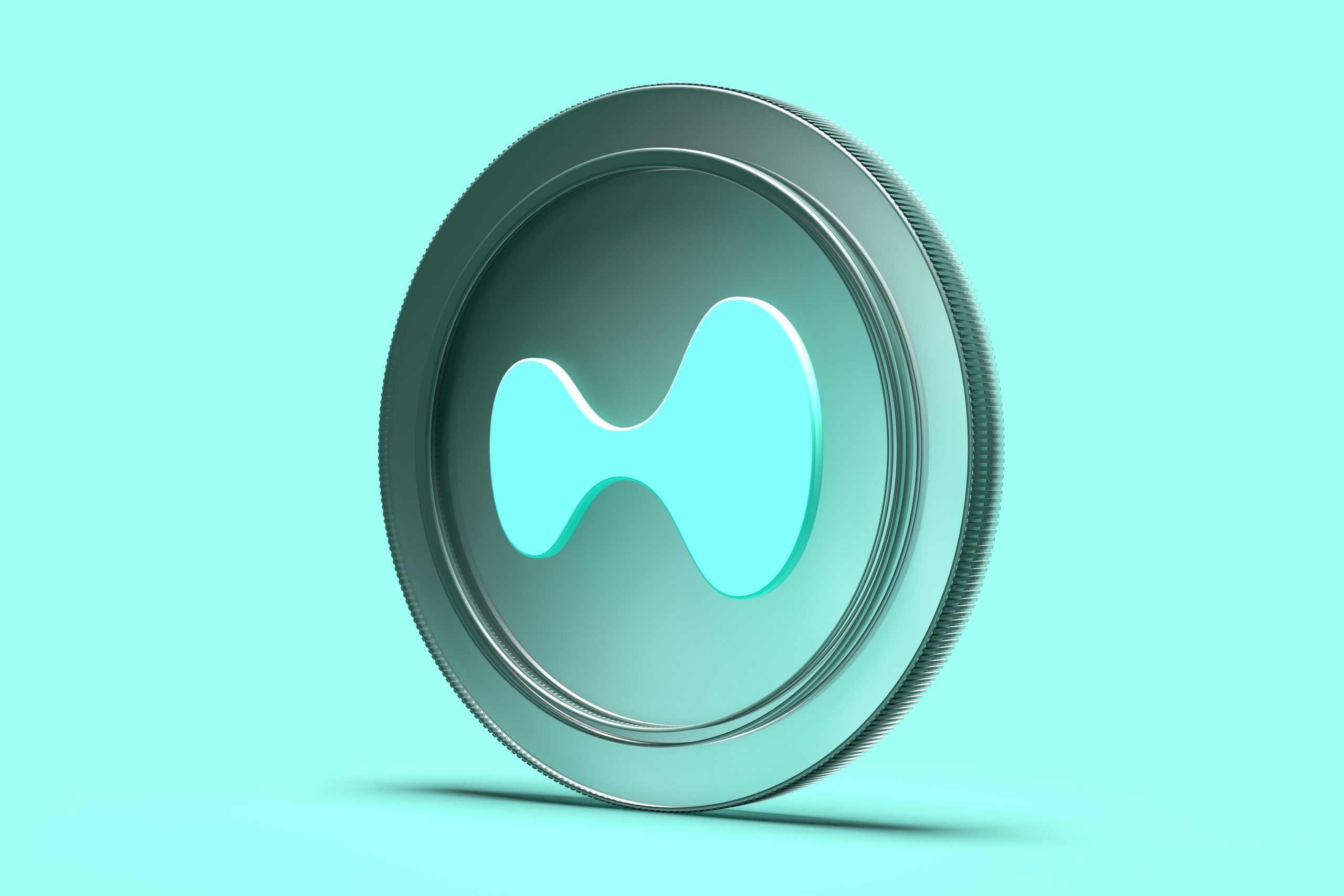 Eine metallische Hyperliquid-Münze mit glatter Oberfläche und einer hellblauen, abstrakten Form, die in der Mitte eingraviert ist, vor einem passenden hellblauen Hintergrund.