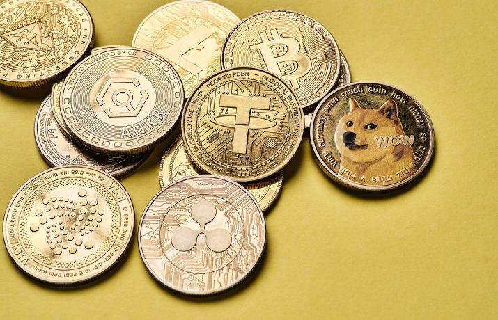 Eine Sammlung verschiedener Krypto-Münzen, darunter Bitcoin, Tether, Dogecoin und andere, angeordnet auf einem gelben Hintergrund.