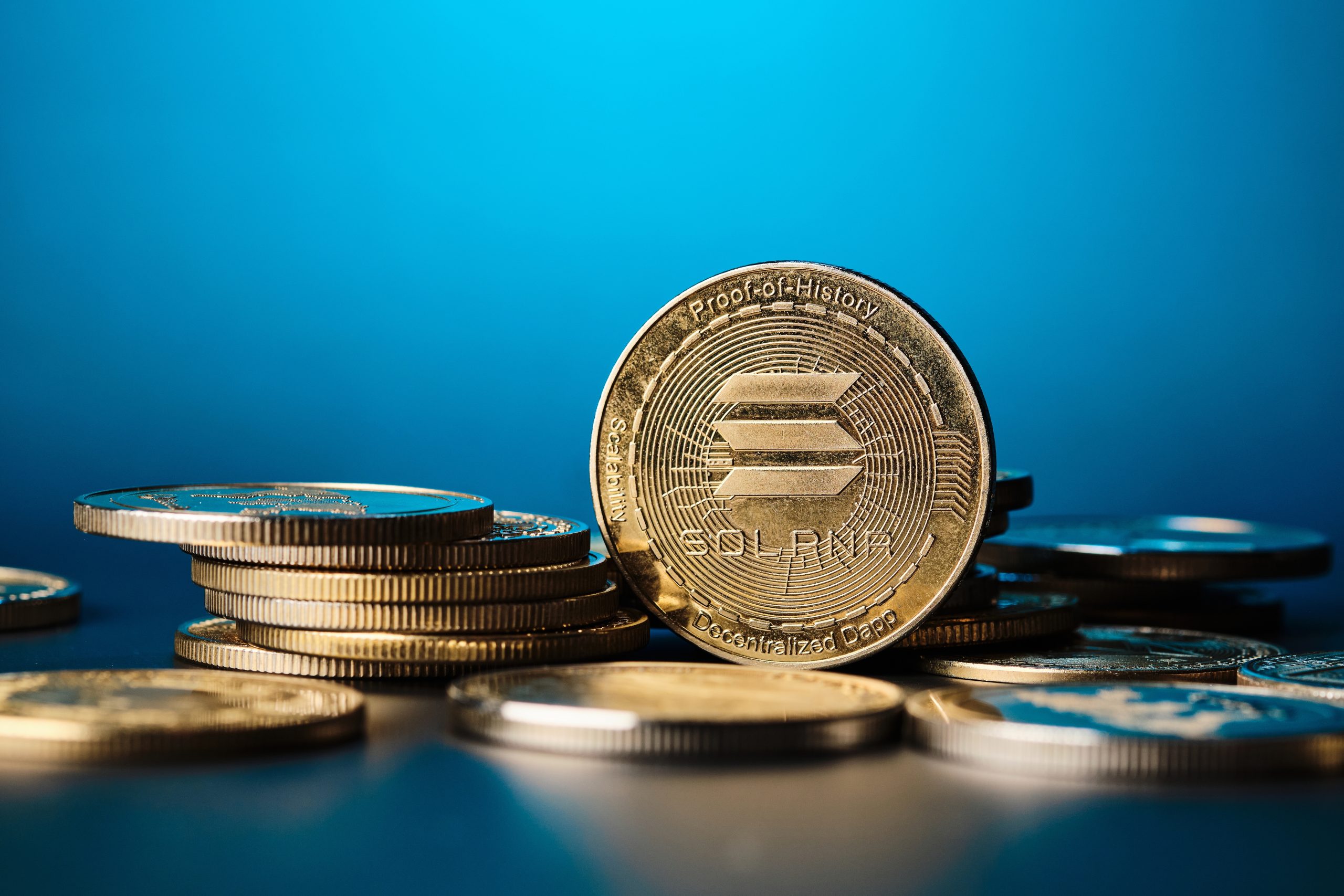 Ein Stapel glänzender Solana-Münzen wird vor einem blauen Hintergrund mit Farbverlauf angezeigt.